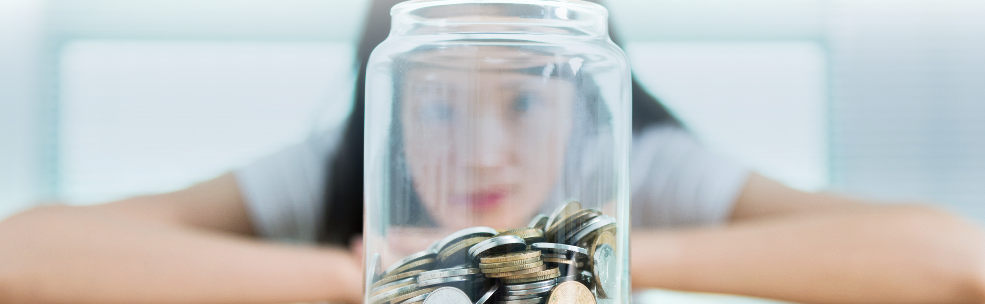 little girl saving money in a jar