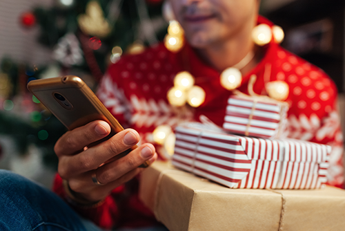 man holding stack of wrapped Christmas gifts