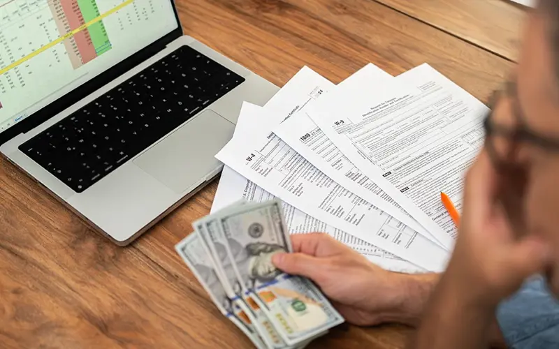 man looking at expenses while filling out tax paperwork