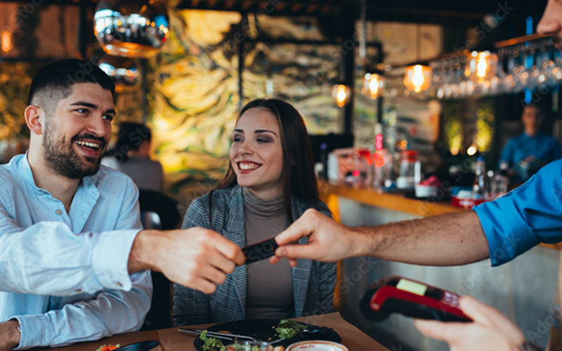 Man handing waiter his credit card after a meal