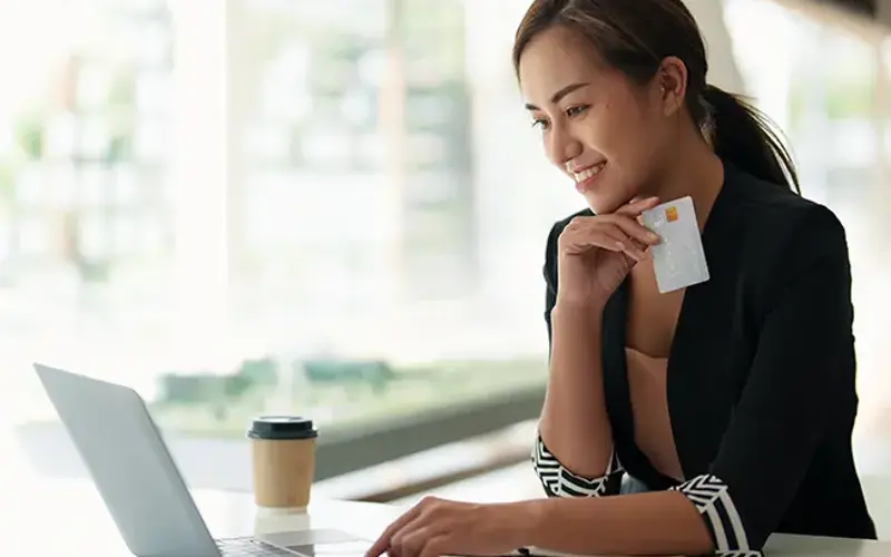 Woman using laptop with credit card