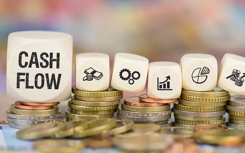 stacks of coins holding dice that each include a financial icon