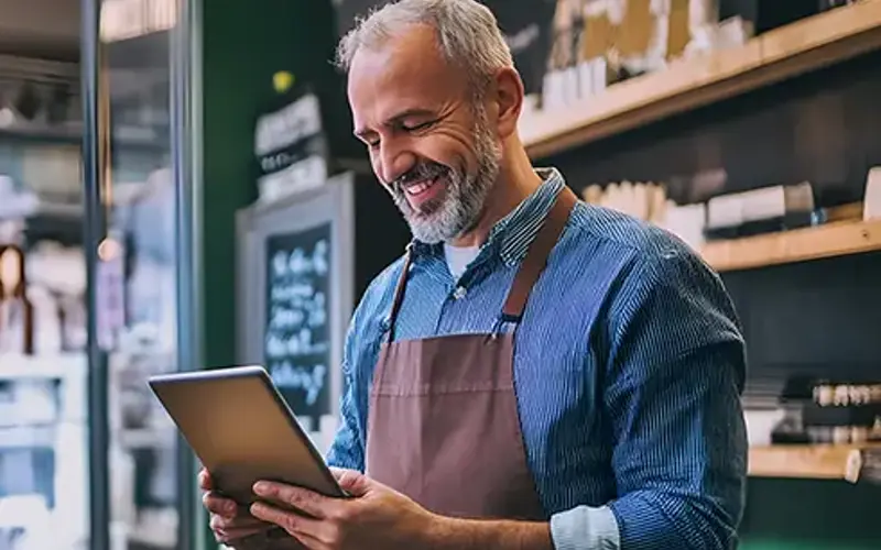 Small business owner using a digital device to manage assets