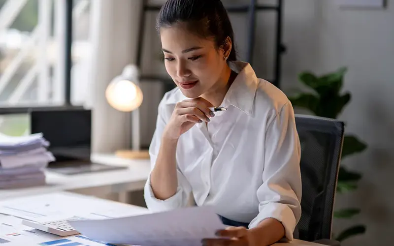 Businesswoman working and reading financial graph document at office