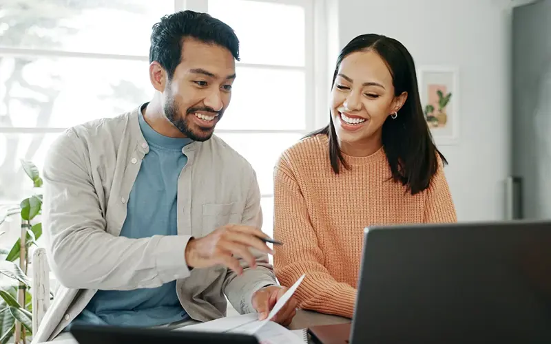 Kitchen, couple and discussion with laptop for budget, track expenses and planning for financial goals