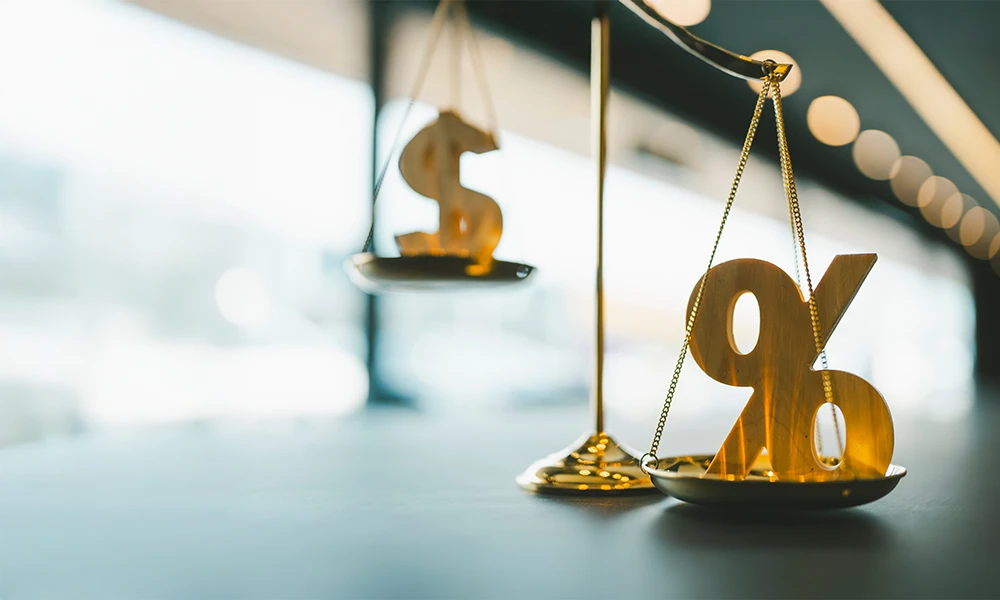 the scales of justice balancing a money sign and a percentage sign