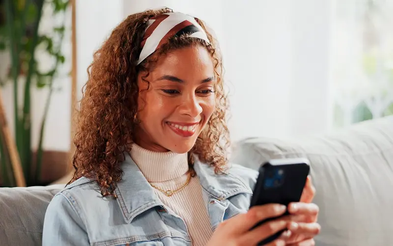 young woman smiling while on her mobile phone