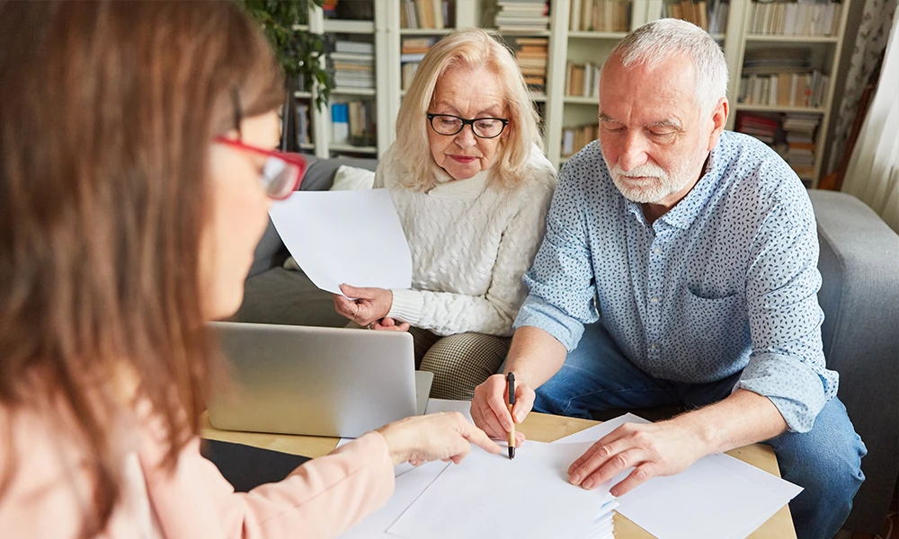 elderly couple signing paperwork