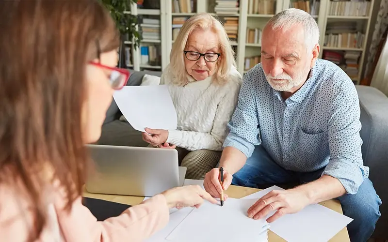 elderly couple signing paperwork