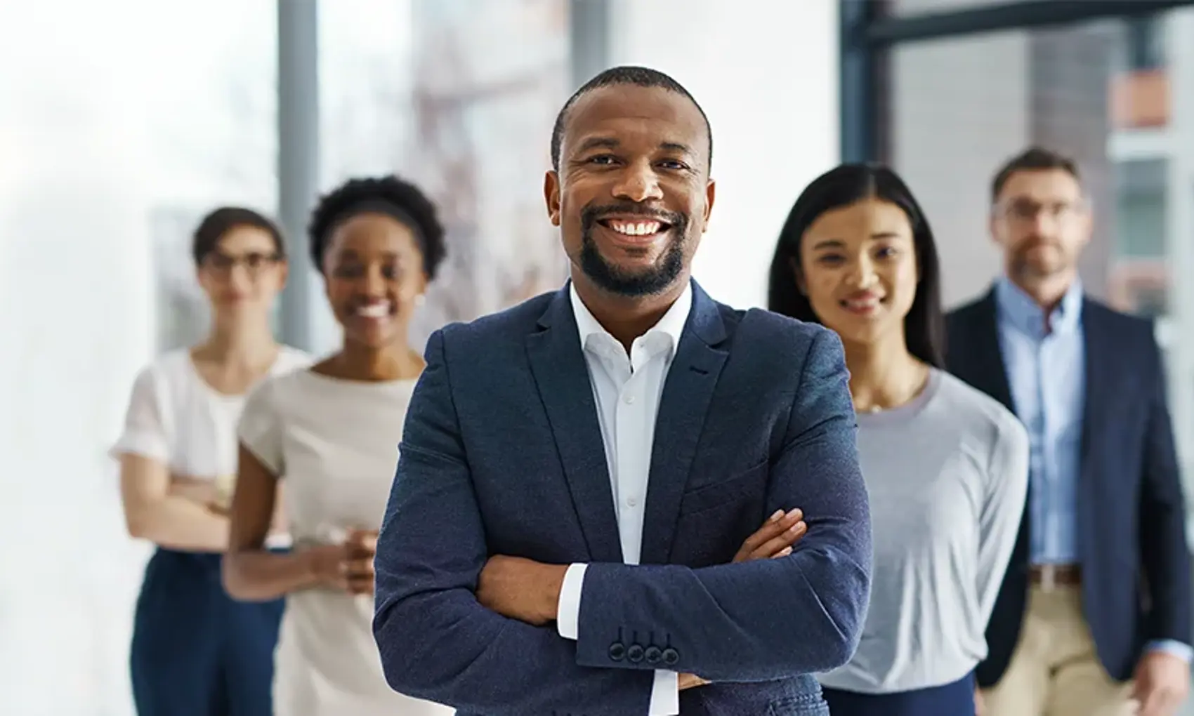 Professional and successful business team smiling and standing together in an office.