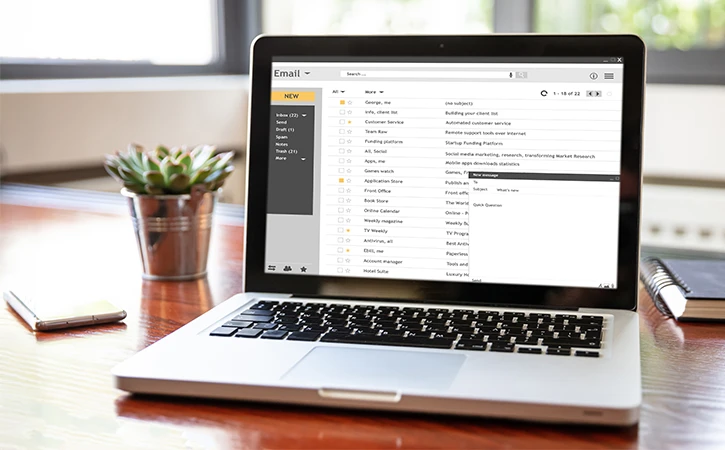 laptop on desk showing email application 