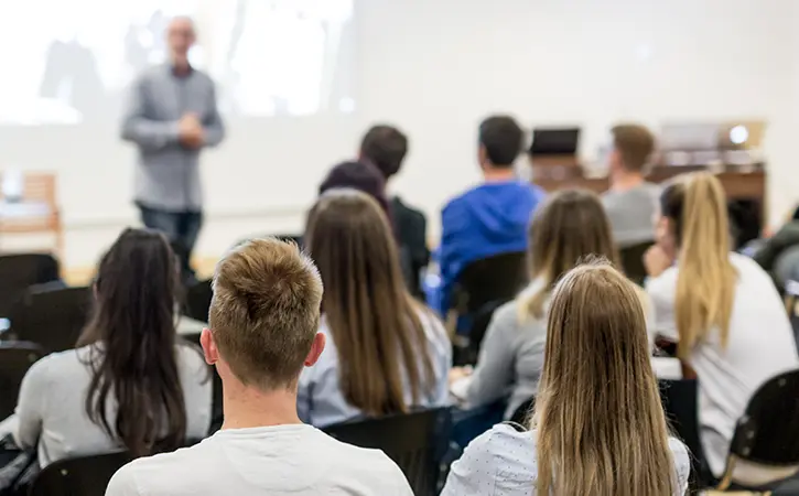 professor teaching college students in a classroom