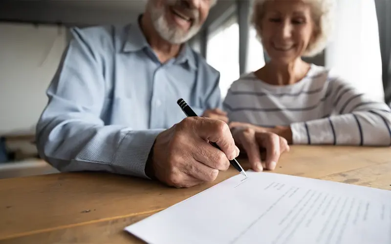 older adult couple signing Power of Attorney paperwork