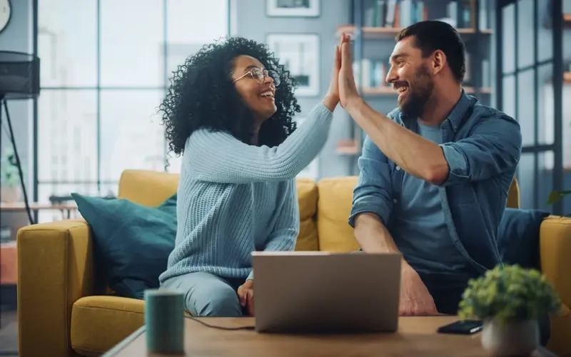 Man and woman on couch high fiving