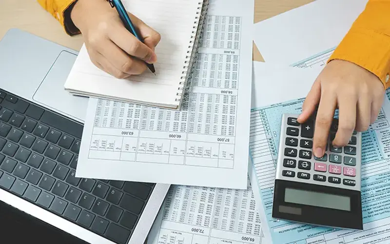 person reviewing finances and using a calculator