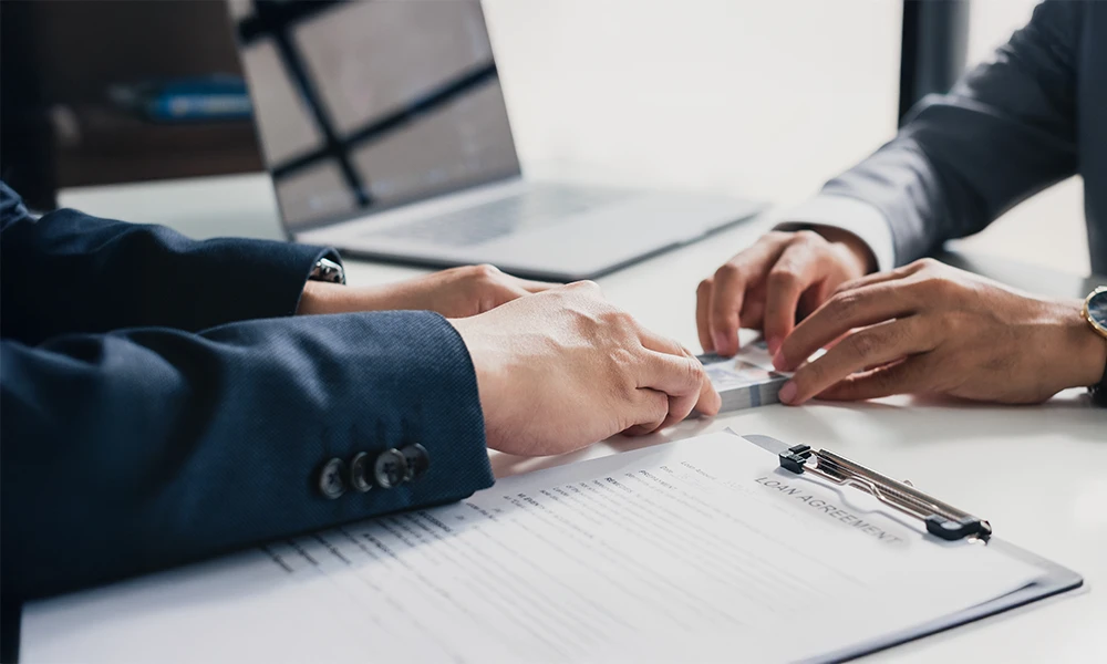 2 men in suits going over a loan agreement