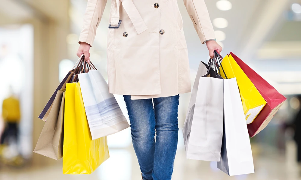 woman carrying many department store shopping bags