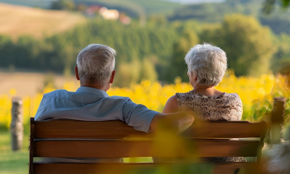 older couple enjoying the view from a bench outside