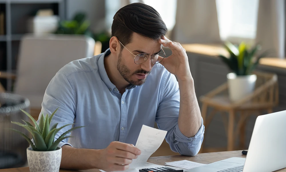 frustrated man looking at receipts