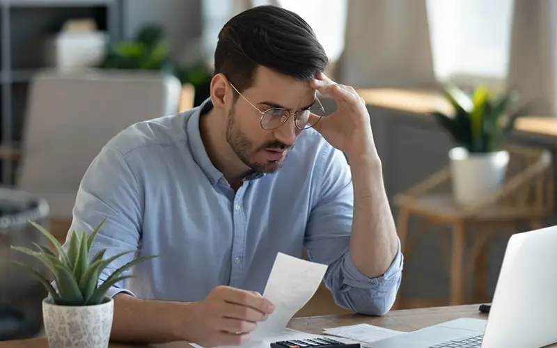frustrated man looking at receipts