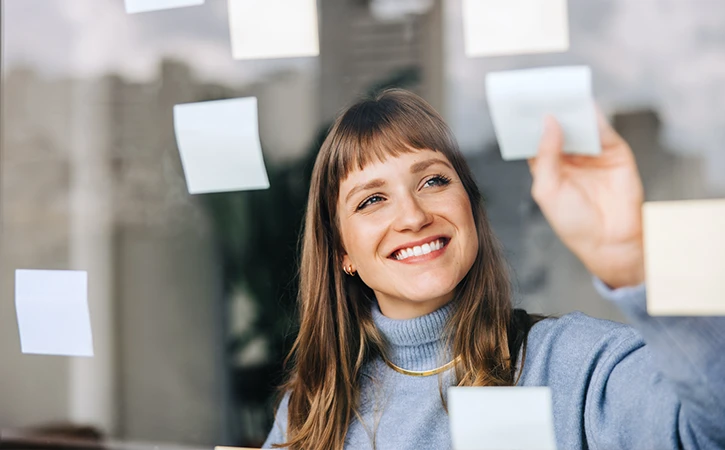 woman placing various post-its on a window