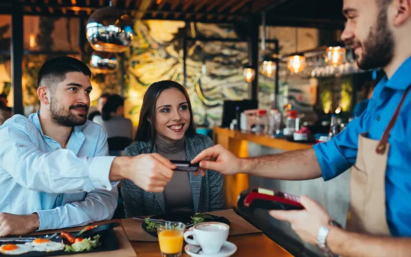 man handing waiter credit card