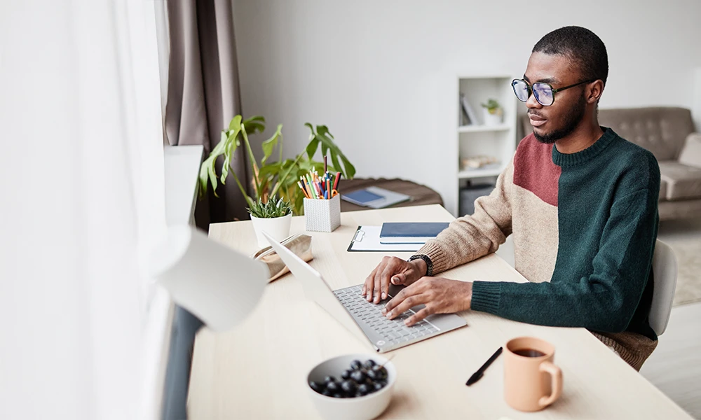 Man typing on laptop in home office