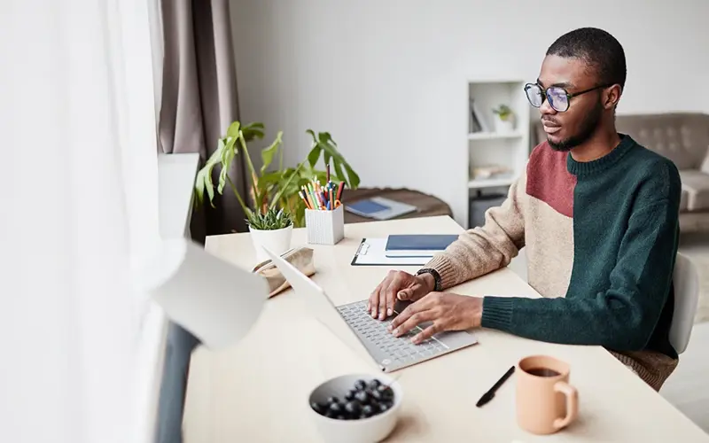 Man typing on laptop in home office