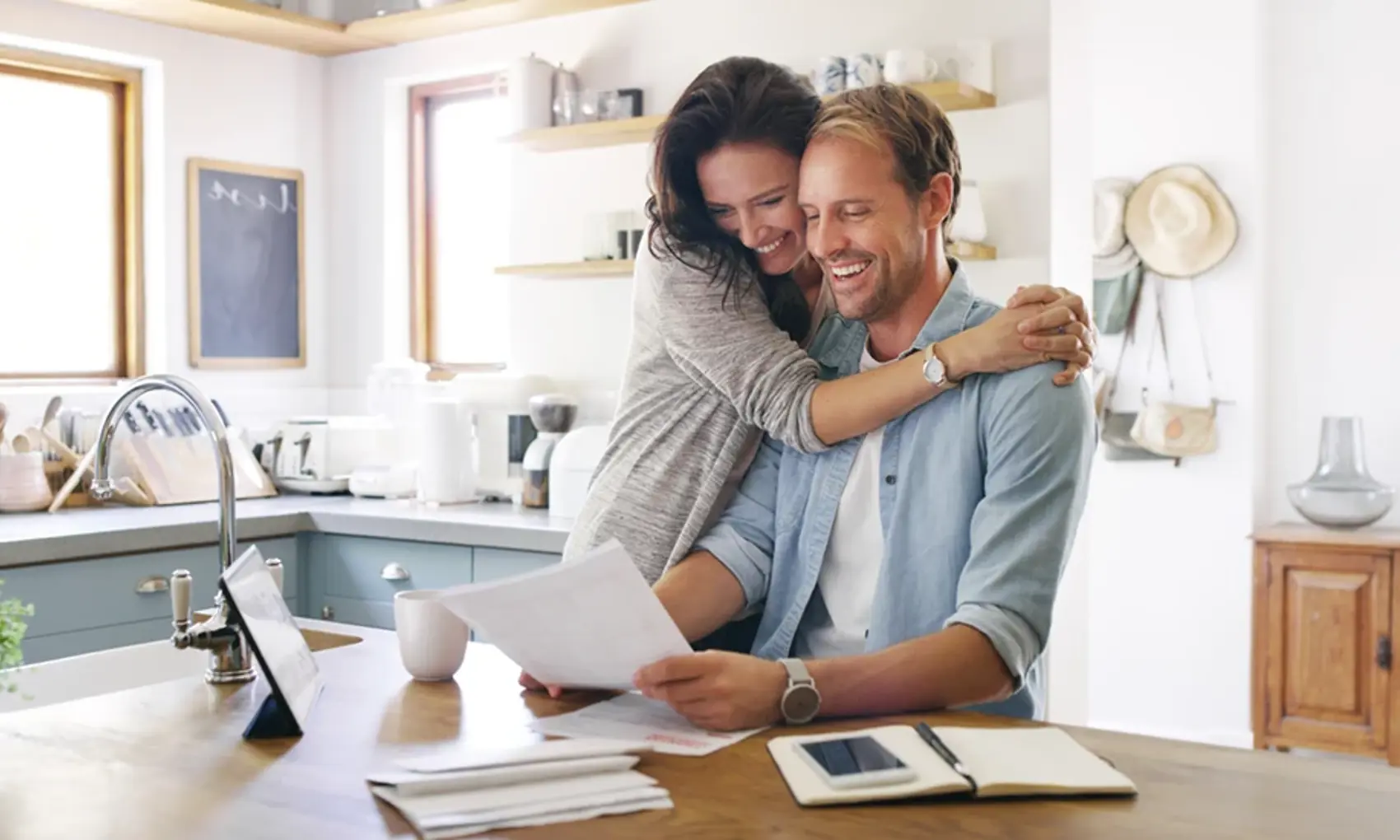 Man and woman in kitchen reviewing paperwork