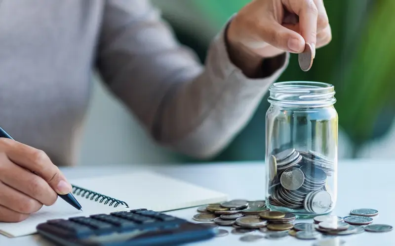 Woman putting coins in a jar