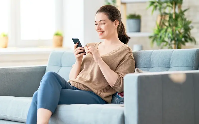 Woman with a phone on couch